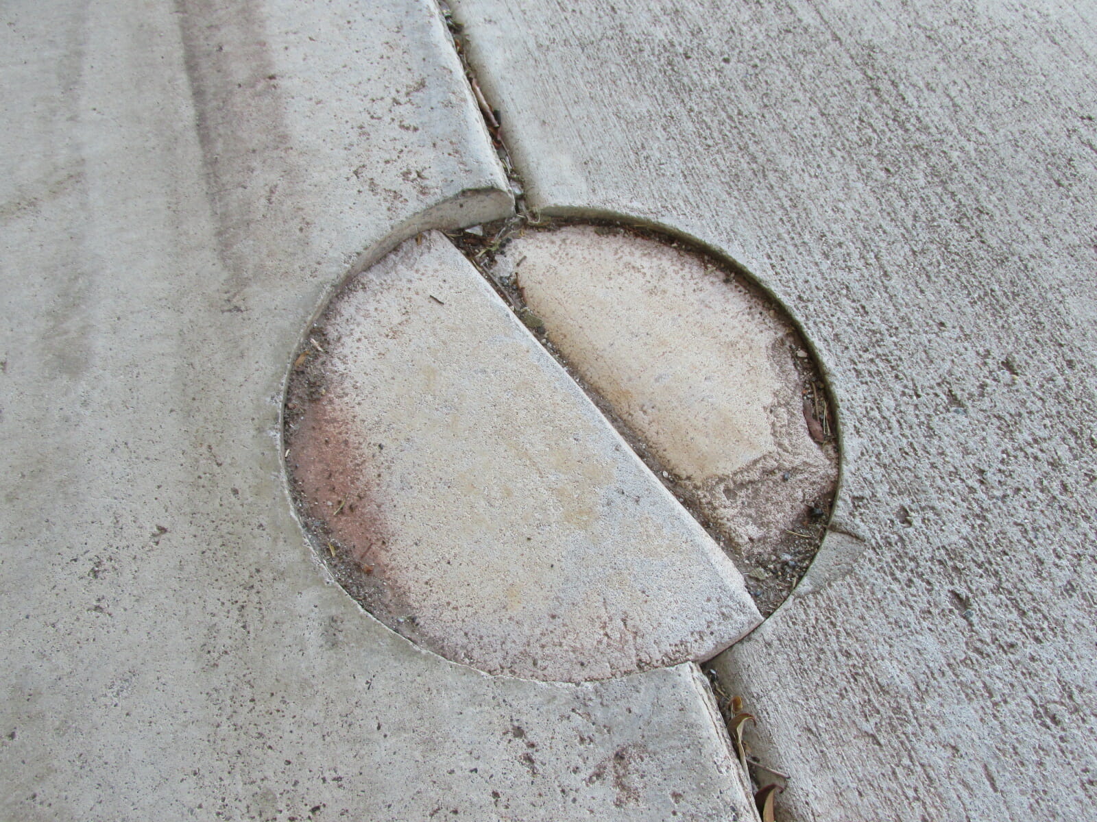 Patched Holes in Garage Floor:  Structural Issues Or For Pest Control Treatment?