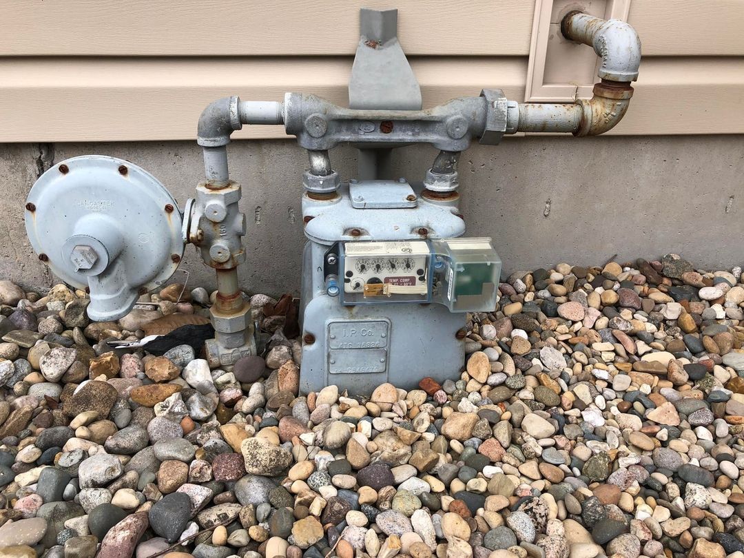 Gas meter submerged in gravel rusting