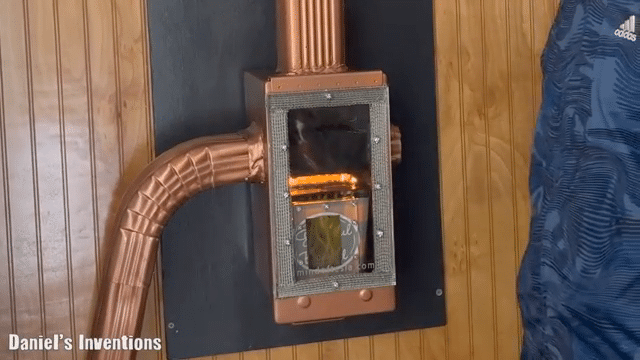 A wall-mounted fireplace with a glass front and copper piping is visible, alongside a hanging dark blue Adidas jacket. A caption